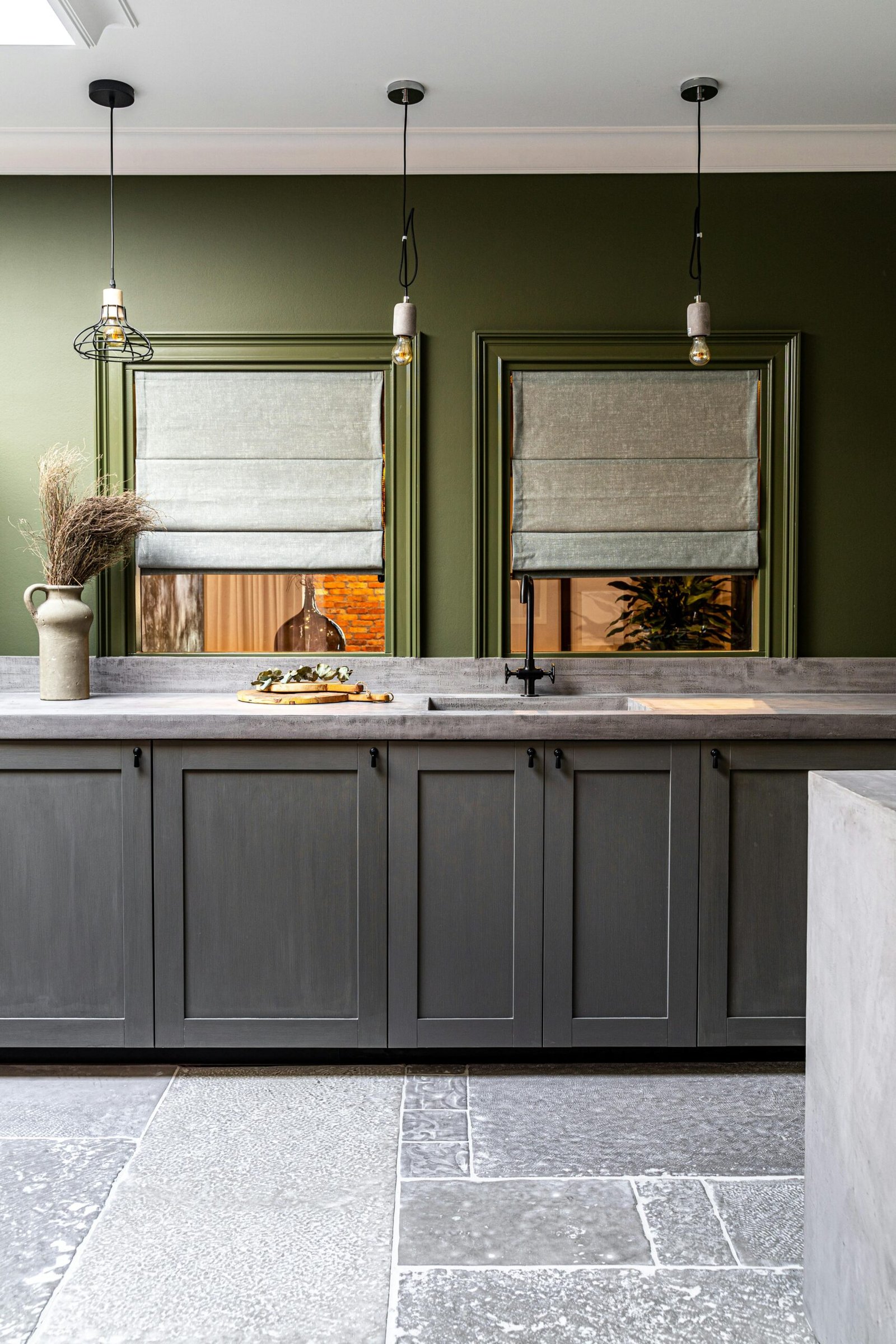 Modern minimalist kitchen with green accents and sleek design in natural lighting.